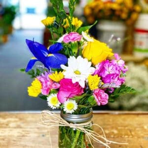 Bright and colorful mixed flower bouquet in a mason jar.