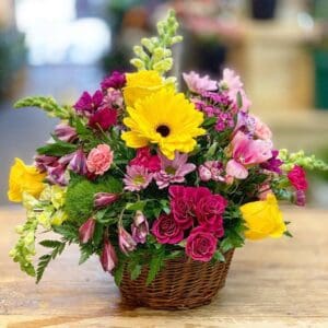 Colorful flower arrangement in a wicker basket.