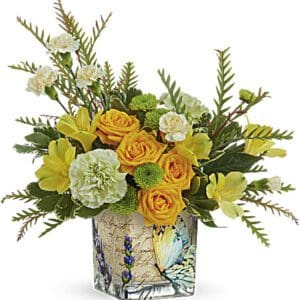 A vibrant bouquet of yellow roses and green foliage in a decorative vase.
