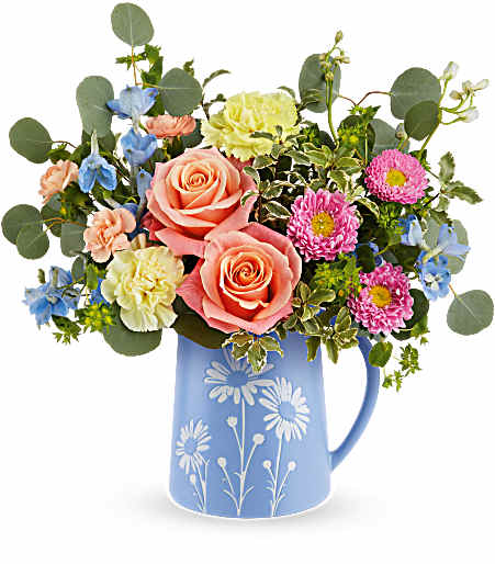 Pastel mixed-flower bouquet in blue daisy pitcher