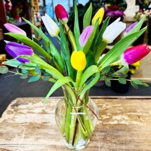 Bright multicolored tulips in glass vase