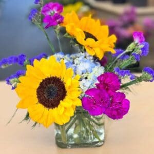 Sunflowers and mixed blooms in glass vase