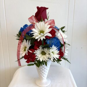 Red, white, blue floral arrangement in vase