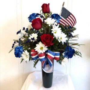 Patriotic red, white, blue floral arrangement with flag