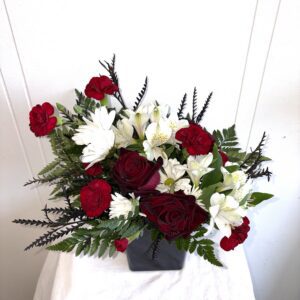 Red and white floral bouquet in black vase